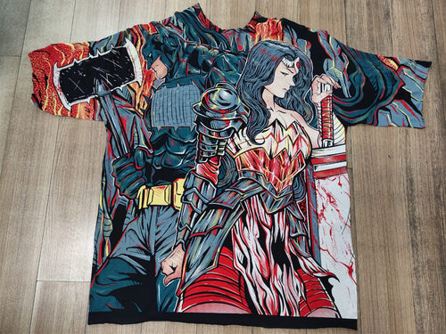 A long short sleeve t-shirt with a highly detailed, colorful anime-style graphic print of a female samurai warrior, laid flat on a light brown wooden floor.